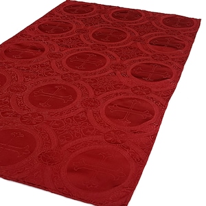 May include: Red fabric with a repeating pattern of embossed circles containing a cross design.