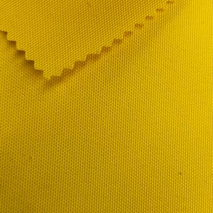 Puede incluir: Primer plano de una tela de color amarillo brillante con textura tejida. La tela está doblada sobre sí misma, mostrando el revés del material.