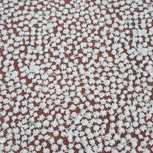 May include: White lace fabric with a delicate floral pattern. The fabric is made of a fine mesh with small, raised flowers.