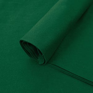 May include: A roll of dark green felt fabric. The fabric is folded and rolled up, with the edges visible. The fabric is smooth and has a soft texture. Daylin Fabrics is printed on the bottom right corner of the image.