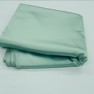 May include: A folded piece of light green satin fabric.
