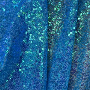 May include: A vibrant blue fabric featuring a dense overlay of shimmering, circular sequins. The material has a semi-sheer mesh base, and the sequins exhibit a reflective, iridescent quality that shifts between shades of bright blue and teal green.