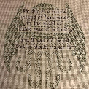 May include: Cross-stitch embroidery of a green Cthulhu with the quote "We live on a placid island of ignorance in the midst of black seas of infinity, and it was not meant that we should voyage far."