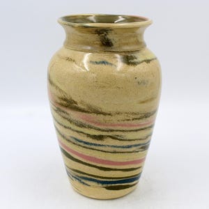 May include: A ceramic vase with a light brown glaze and a swirling pattern of dark brown, blue, and pink lines.