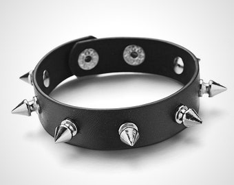 Bracelet en cuir synthétique polyuréthane noir avec rivets à une rangée. Punk, gothique, death metal, soul sombre.