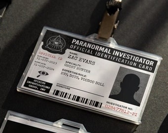 May include: Two black and white paranormal investigator identification cards with a barcode and text. The top card has a silhouette of a person and the text "PARANORMAL INVESTIGATOR OFFICIAL IDENTIFICATION CARD NAME ZAO EVANS SPECIALTY GHOST HUNTER EXPERTISE ROLE EVI, DOTS, VOODOO DOLL INVESTIGATOR NO. 029477812-PI". The bottom card has the text "PARANORMAL INVESTIGATOR INVESTIGATIVE GROUP Spirits Investigations, Inc INVESTIGATOR NO. 028477812-PI".