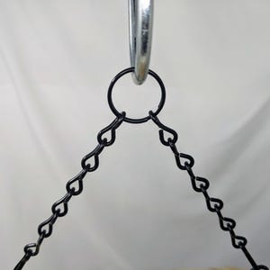 Puede incluir: Primer plano de una cadena de metal negro unida a un anillo plateado. La cadena est&aacute; hecha de peque&ntilde;os eslabones en forma de coraz&oacute;n.