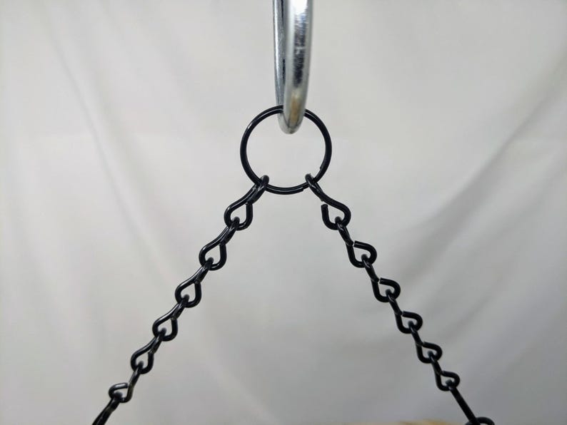 Puede incluir: Primer plano de una cadena de metal negro unida a un anillo plateado. La cadena est&aacute; hecha de peque&ntilde;os eslabones en forma de coraz&oacute;n.