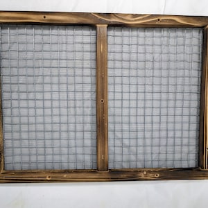 May include: A rustic wooden frame with a wire mesh insert. The frame is stained a dark brown color and has a distressed look. The mesh is a silver color and is visible through the frame.