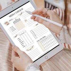 May include: A weekly check-in planner on a tablet with sections for tracking healthy habits, meals, exercise, and ketone readings. The planner includes a grid for tracking daily habits, a meal tracker with columns for carbs, protein, and fat, and a section for recording exercise.