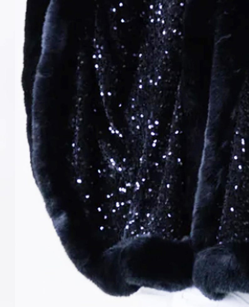 May include: Black sequined fabric with a black fur trim. The fabric is soft and luxurious, and the fur is thick and plush.