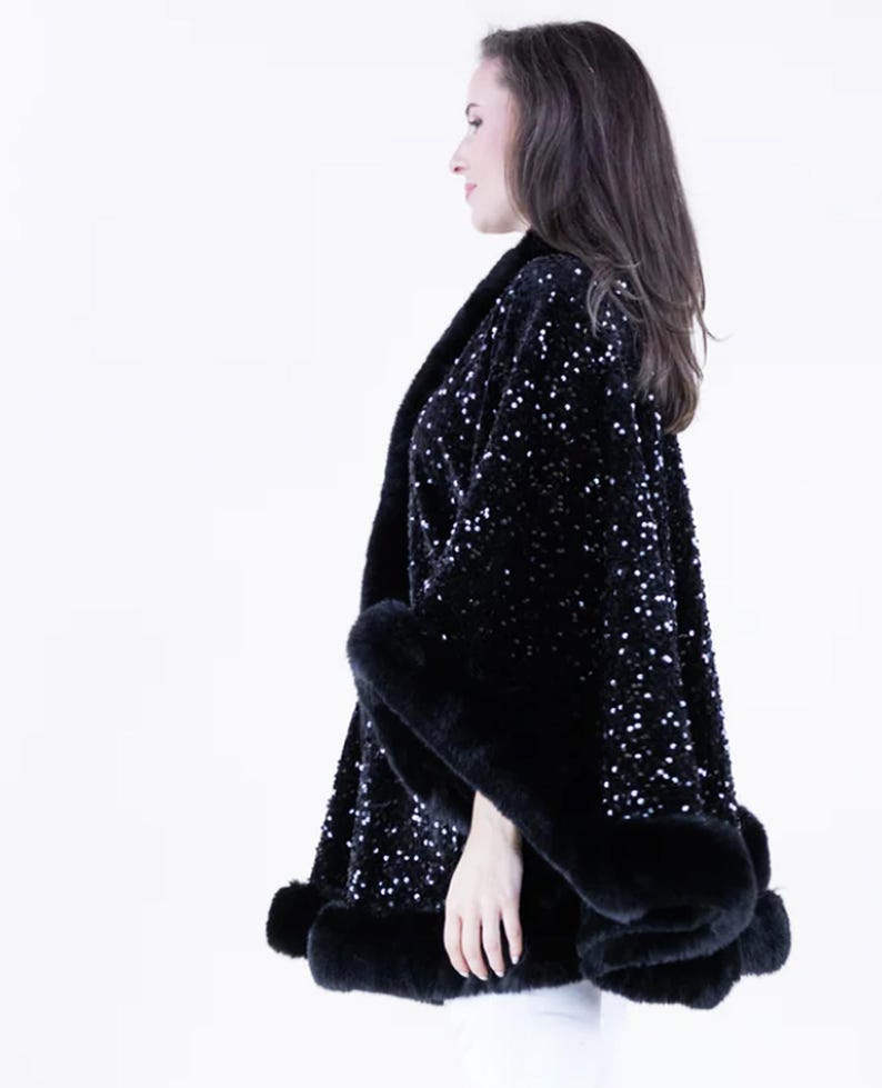 May include: A black sequined cape with a faux fur trim. The cape is open in the front and has a loose fit.