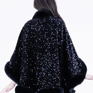 May include: A black sequined cape with a fur trim. The cape is made of a soft, luxurious fabric and features a flattering, flowing silhouette.