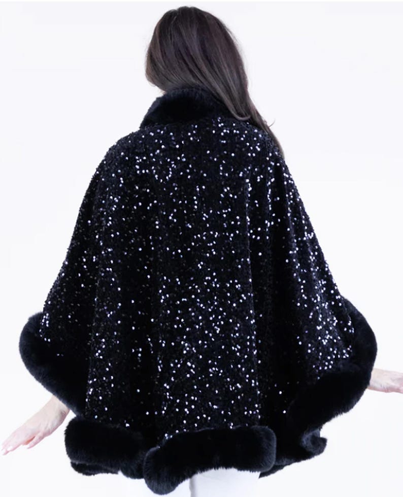 May include: A black sequined cape with a fur trim. The cape is made of a soft, luxurious fabric and features a flattering, flowing silhouette.