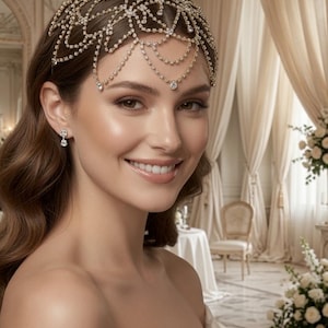 May include: A gold-toned headpiece featuring an intricate lattice design adorned with clear crystals. The accessory drapes across the forehead with delicate chain strands and small crystal accents, complemented by matching crystal drop earrings.