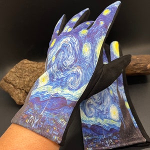 May include: A pair of gardening gloves featuring a print of Van Gogh's "Starry Night" painting. The gloves have a black palm and fingers, with the famous swirling blue, yellow, and white night sky design on the back of the hand.