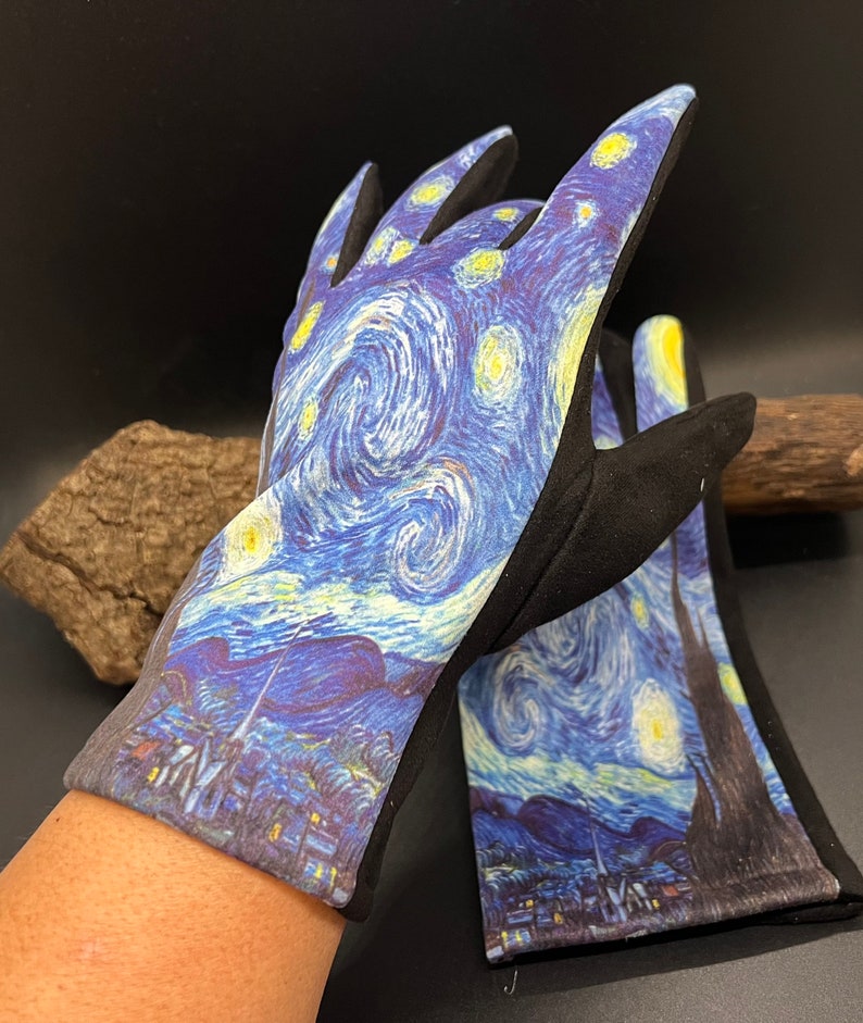 May include: A pair of gardening gloves featuring a print of Van Gogh's "Starry Night" painting. The gloves have a black palm and fingers, with the famous swirling blue, yellow, and white night sky design on the back of the hand.