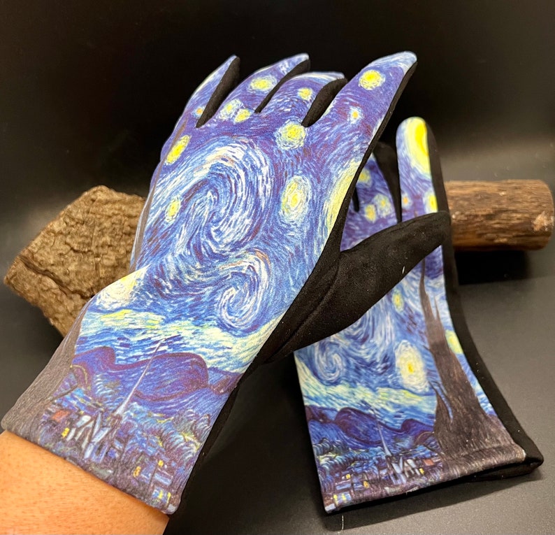 May include: A pair of gardening gloves featuring a print of Van Gogh's "Starry Night" painting. The gloves have a black palm and finger area, with the artwork covering the back of the hand and fingers. The artwork includes swirling blue, yellow, and white colors.