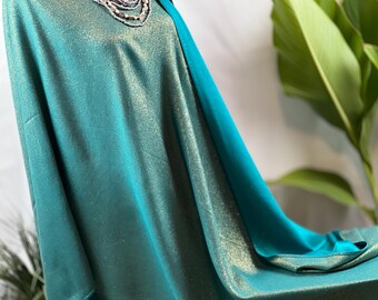 May include: Teal fabric with a subtle shimmer, possibly a shawl or scarf. The fabric has a smooth, silky texture.