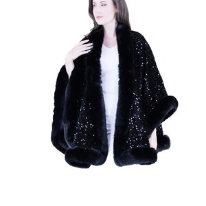 May include: A black sequined cape with a faux fur trim. The cape is worn by a model and has a shawl collar.