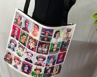 May include: White tote bag featuring a grid of portraits of Frida Kahlo. The portraits vary in style and color, showcasing her iconic image. The bag has black handles and a zipper closure, suitable for carrying various items.