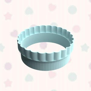 May include: A light blue, two-tiered cookie cutter with a scalloped edge. The cutter is made of plastic and is designed for baking. The background is a light pink with repeating shapes.