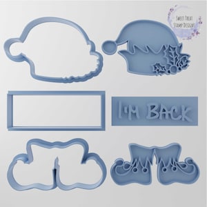May include: A set of five blue cookie cutters, including a Santa hat, elf hat, elf shoes, a banner that says "I'm Back", and a cloud shape.