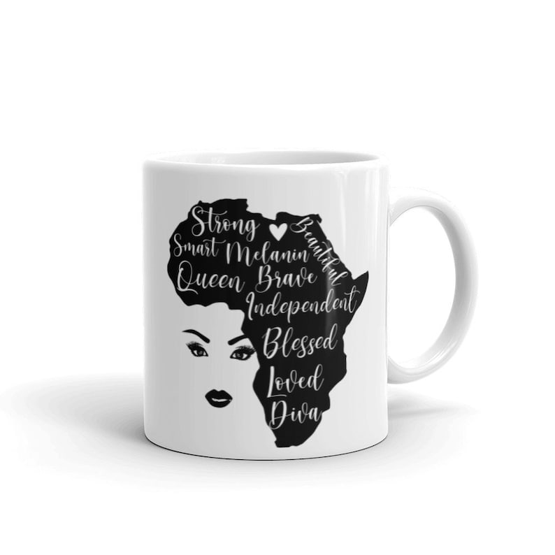 Pode incluir: Caneca de cer&acirc;mica branca com uma silhueta preta do continente africano. O continente &eacute; contornado por palavras como "Strong", "Smart", "Melanin", "Queen", "Brave", "Independent", "Blessed", "Loved" e "Diva". Um pequeno cora&ccedil;&atilde;o est&aacute; no centro do continente.
