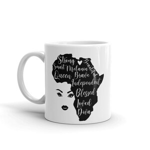 Pode incluir: Caneca de cer&acirc;mica branca com uma silhueta preta do continente africano. O continente &eacute; delineado com palavras que descrevem atributos positivos, como "Strong", "Smart", "Melanin", "Beautiful", "Queen", "Brave", "Independent", "Blessed", "Loved" e "Diva".
