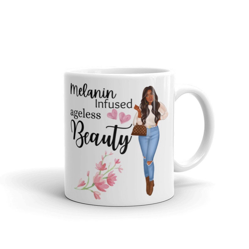 May include: White ceramic mug with a black and white graphic of a woman with brown hair and a white shirt. The text on the mug reads "Melanin Infused ageless Beauty" with two pink hearts.