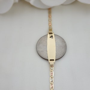 K&ouml;nnte beinhalten: Ein goldenes Armband mit einem Anh&auml;nger in Form eines Herzens. Das Armband besteht aus drei verschiedenen Goldfarben: Gelb, Wei&szlig; und Rotgold.