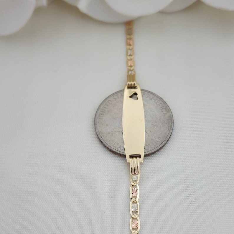 K&ouml;nnte beinhalten: Ein goldenes Armband mit einem Anh&auml;nger in Form eines Herzens. Das Armband besteht aus drei verschiedenen Goldfarben: Gelb, Wei&szlig; und Rotgold.
