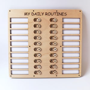Puede incluir: Un tablero de rutinas diarias de madera con el texto "MY DAILY ROUTINES" en la parte superior. Cuenta con ranuras para tareas e interruptores basculantes marcados con los símbolos "X" y "O".