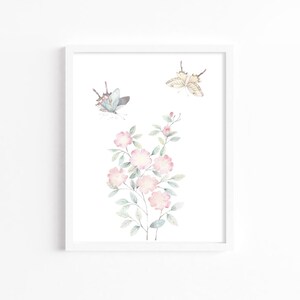 Op de afbeelding: Ingelijste kunstafdruk met roze bloemen en vlinders. Het kunstwerk toont delicate roze bloesems met groene bladeren en twee vlinders. De vlinders hebben blauwe en bruine vleugels.