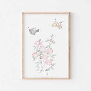 Op de afbeelding: Ingelijste aquarelprint van roze bloemen en vlinders. Het kunstwerk toont twee vlinders en een bloemstuk met lichtroze bloesems en groene bladeren. De vlinders hebben blauwe en beige vleugels.