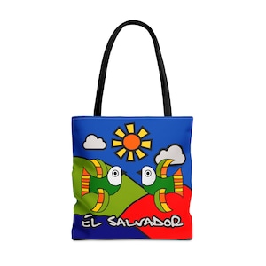 Peut inclure: Un sac fourre-tout bleu avec un motif coloré représentant deux poissons stylisés, un soleil et des nuages. Le texte "EL SALVADOR" est imprimé sur le sac.