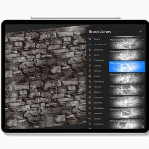 Puede incluir: Una pantalla de tableta que muestra una interfaz de biblioteca de pinceles digitales con una lista de pinceles de piedra. El lado izquierdo muestra una vista previa de una textura de pared de piedra gris, mientras que el derecho lista opciones.