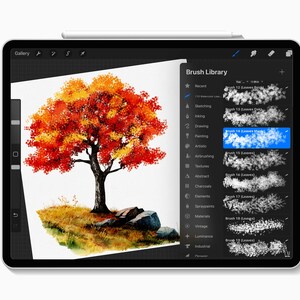 May include: A digital painting of a tree with vibrant red and yellow leaves on a tablet screen. The tree is set against a white background with a grassy area and rocks at the base. The screen displays a brush library.