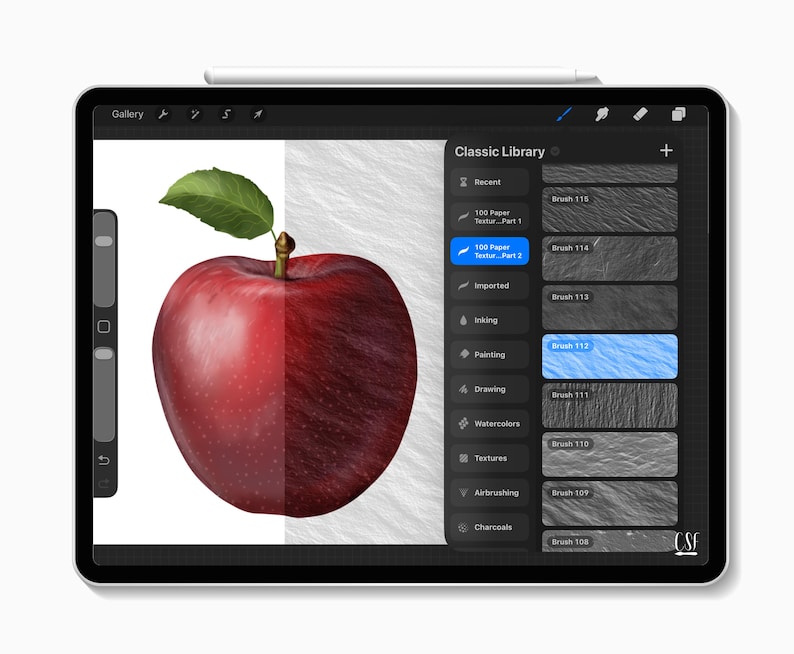 Puede incluir: Ilustraci&oacute;n digital de una manzana roja con una hoja verde, dividida para mostrar una superficie texturizada. La imagen se muestra en una tableta con un l&aacute;piz &oacute;ptico, mostrando herramientas de arte digital.