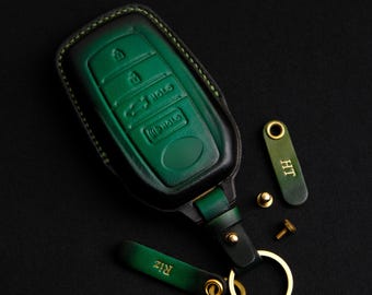 May include: A green leather key fob with a gold key ring and two personalized leather tags that read "RIZ" and "IH".