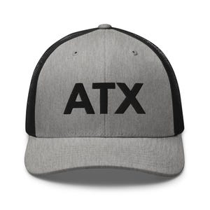 Può includere: Un cappellino da baseball grigio mélange con retro in rete nera e visiera nera. Il pannello frontale presenta le lettere ATX stampate in grassetto maiuscolo nero. Il cappellino ha una corona strutturata e un bottone sulla parte superiore.