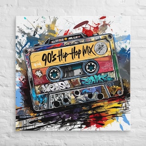 Puede incluir: Impresión en lienzo de una cinta de cassette con el texto "90's Hip Hop Mix". La obra presenta grafitis y salpicaduras de pintura en colores vibrantes, incluyendo rojo, amarillo, azul y negro, creando un estilo retro.