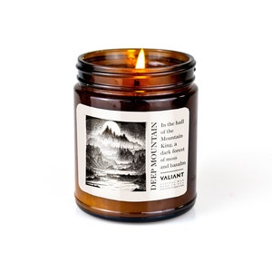 Vela de cera de soja con aroma a montaña profunda, verde hoja y marino oscuro en frasco ámbar.