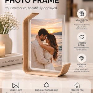 May include: A photo frame featuring a clear acrylic panel held by a curved natural wood base. The frame displays a photograph of a couple embracing at sunset. Text on the image includes PHOTO FRAME, MEANINGFUL GIFT, MODERN DESIGN, and PREMIUM QUALITY.