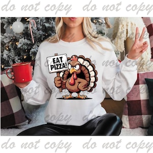 May include: White sweatshirt with a cartoon turkey holding a sign that says "Eat Pizza!" The turkey is brown with a red wattle and a blue and brown tail.