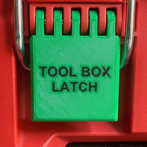 May include: Green plastic latch with the text "TOOL BOX LATCH" in black lettering. The latch is attached to a red toolbox.