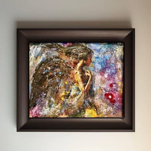 May include: A framed abstract painting of a woman with wings, with a colorful background of blue, purple, yellow, and red.