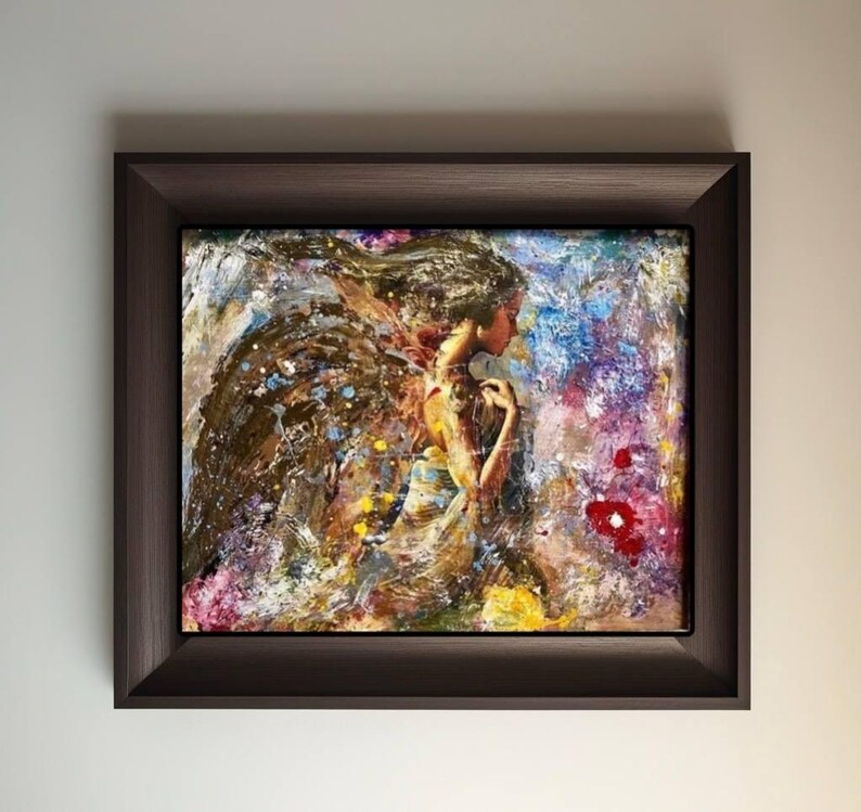 May include: A framed abstract painting of a woman with wings, with a colorful background of blue, purple, yellow, and red.