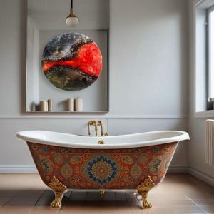 May include: A white clawfoot bathtub with a colorful patterned design. The bathtub has gold-colored feet and is in a bathroom with a mirror and a round abstract painting.
