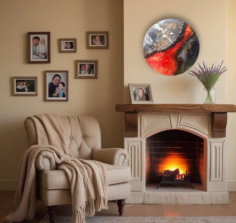 May include: A round, abstract painting with red, white, and black colors. The painting is hanging on a wall above a fireplace. The fireplace has a white mantel and a black fire grate.